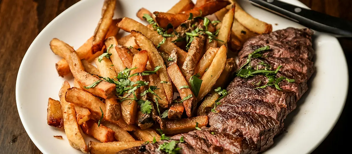Assiette de viande grillée servie avec des frites maison