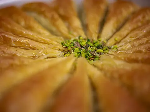 Pâtisseries orientales feuilletées disposées en rosace et parsemées de pistaches
