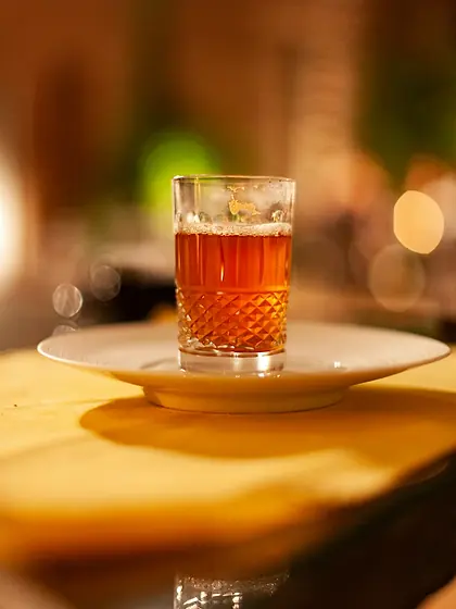Verre de thé posé sur une soucoupe dans la lumière chaude de l’après-midi